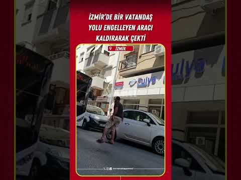 İzmir'de bir vatandaş, yolu engelleyen aracı kaldırarak yoldan çekti.